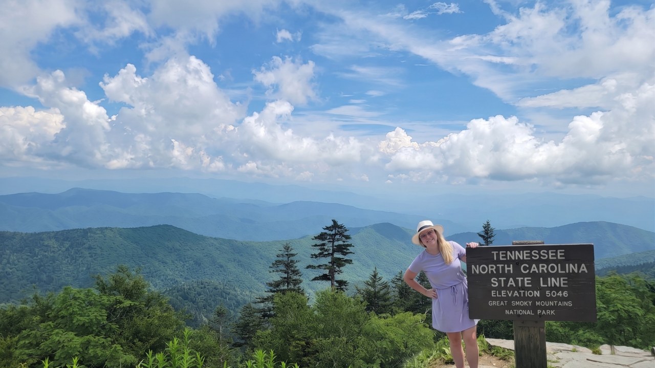 Dr. Nancy Richmond beside the Tennessee and North Carolina state line sign in the Great Smoky Mountains National Park